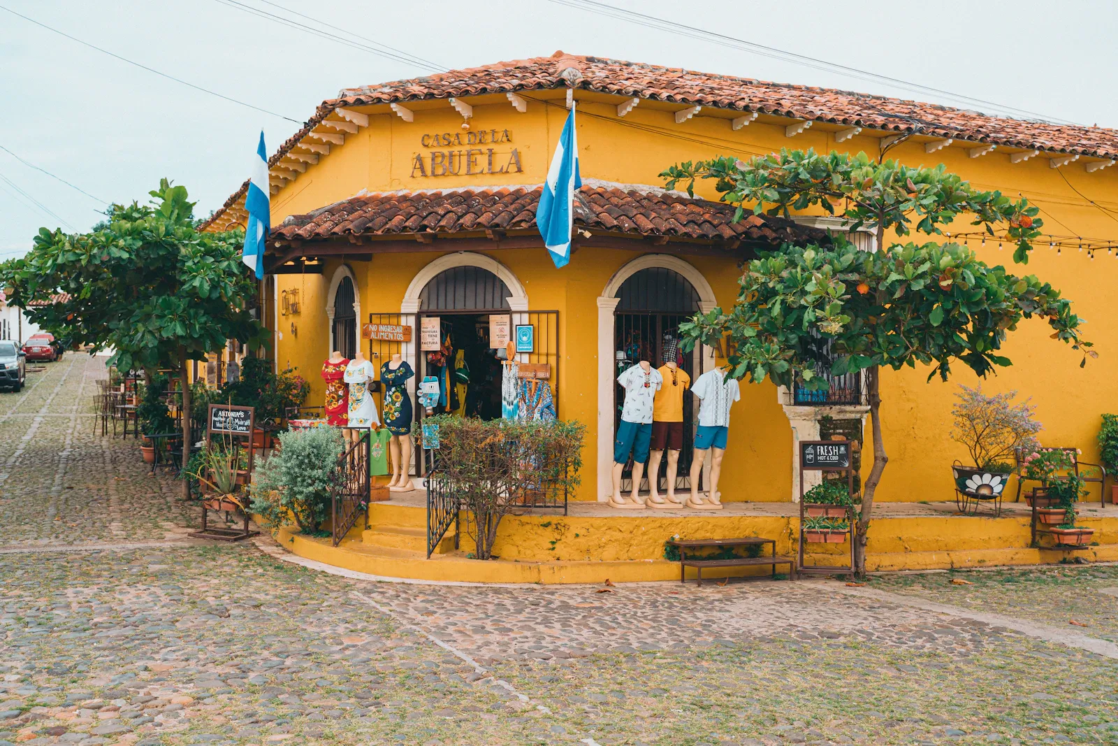 A painted yellow building on a street in one of the Ruta de las Flores towns